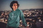 This jade hoodie is soft, smooth and stylish. It is the perfect choice for the cooler evenings, the early morning jump of when you want a bit extra. It has soft cotton faced fabric, double fabric hood with self colour drawstring and front pouch pocket. It has a building and 'send it' shaped as a parachute printed on front.